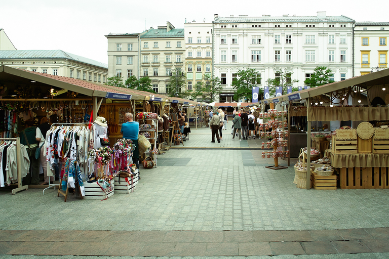 Widok na płytę Rynku Głównego w Krakowie, ma której rozstawione są stoiska - kiermasz. W tle widoczne są kamienice.