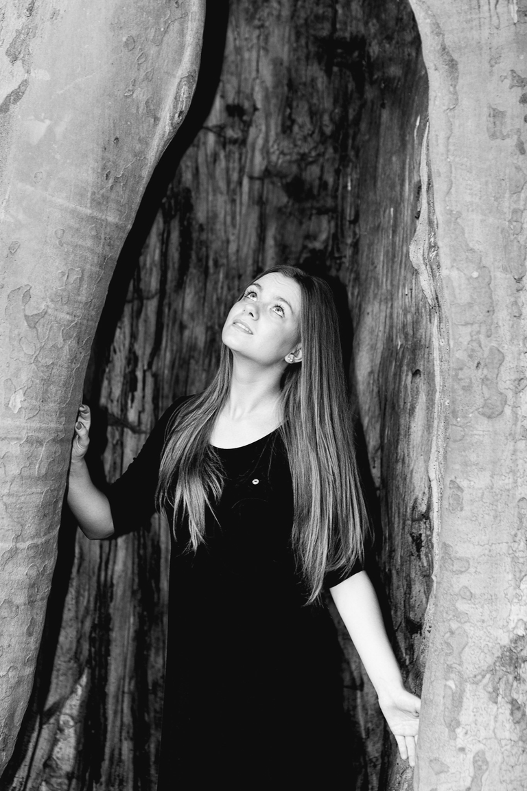 Portretowa sesja zdjęciowa w czerni i bieli. Angelika w pniu drzewa ogrodzie Pałacyku Henryka Sienkiewicza w Oblęgorku.