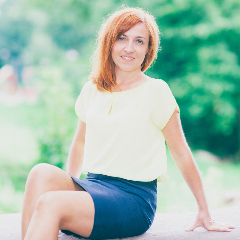 Portretowe sesje zdjęciowe. Monika pozuje siedząc w pięknym, słonecznym, jesiennym świetle.